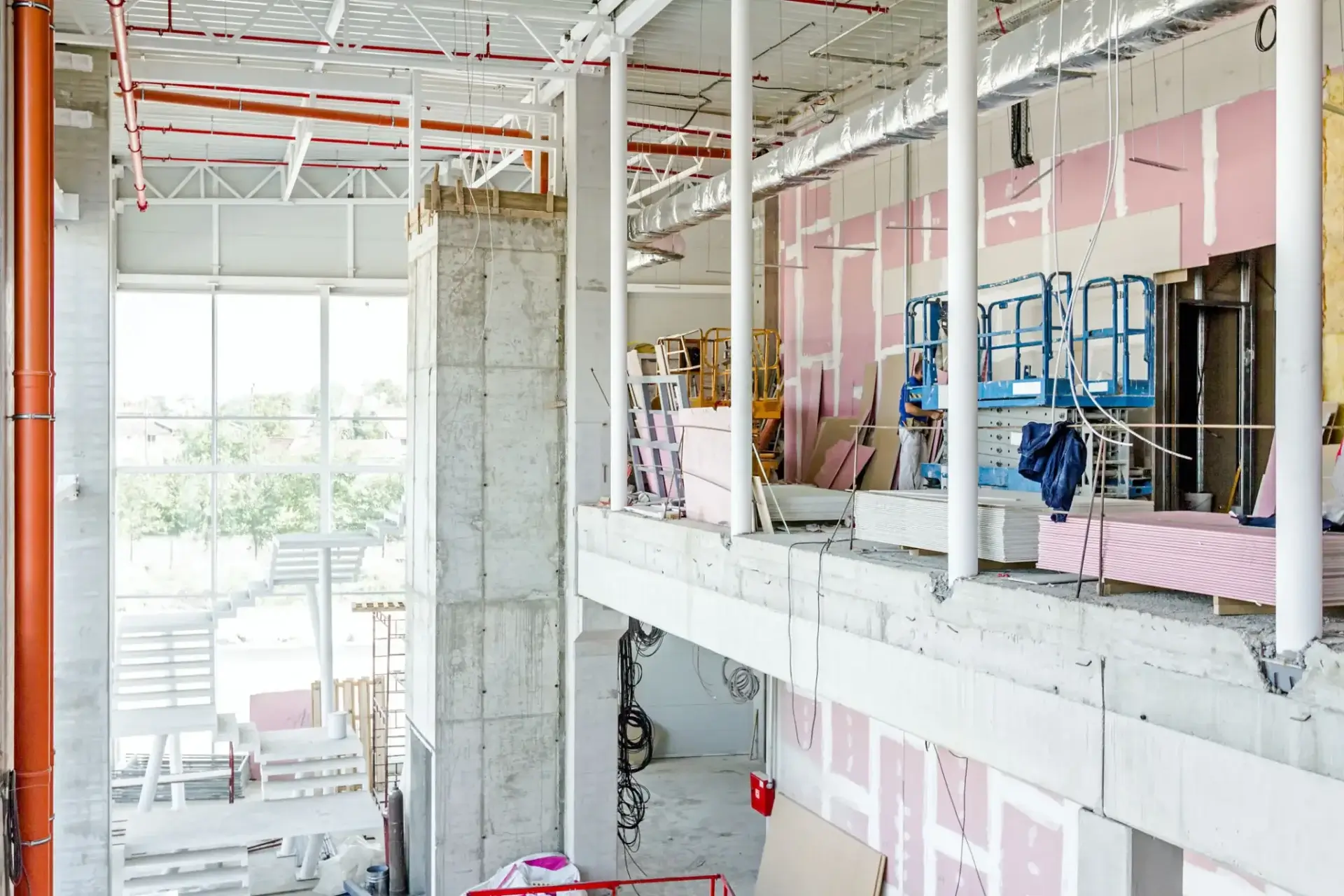 Interior of a building under construction with exposed walls and pipes.