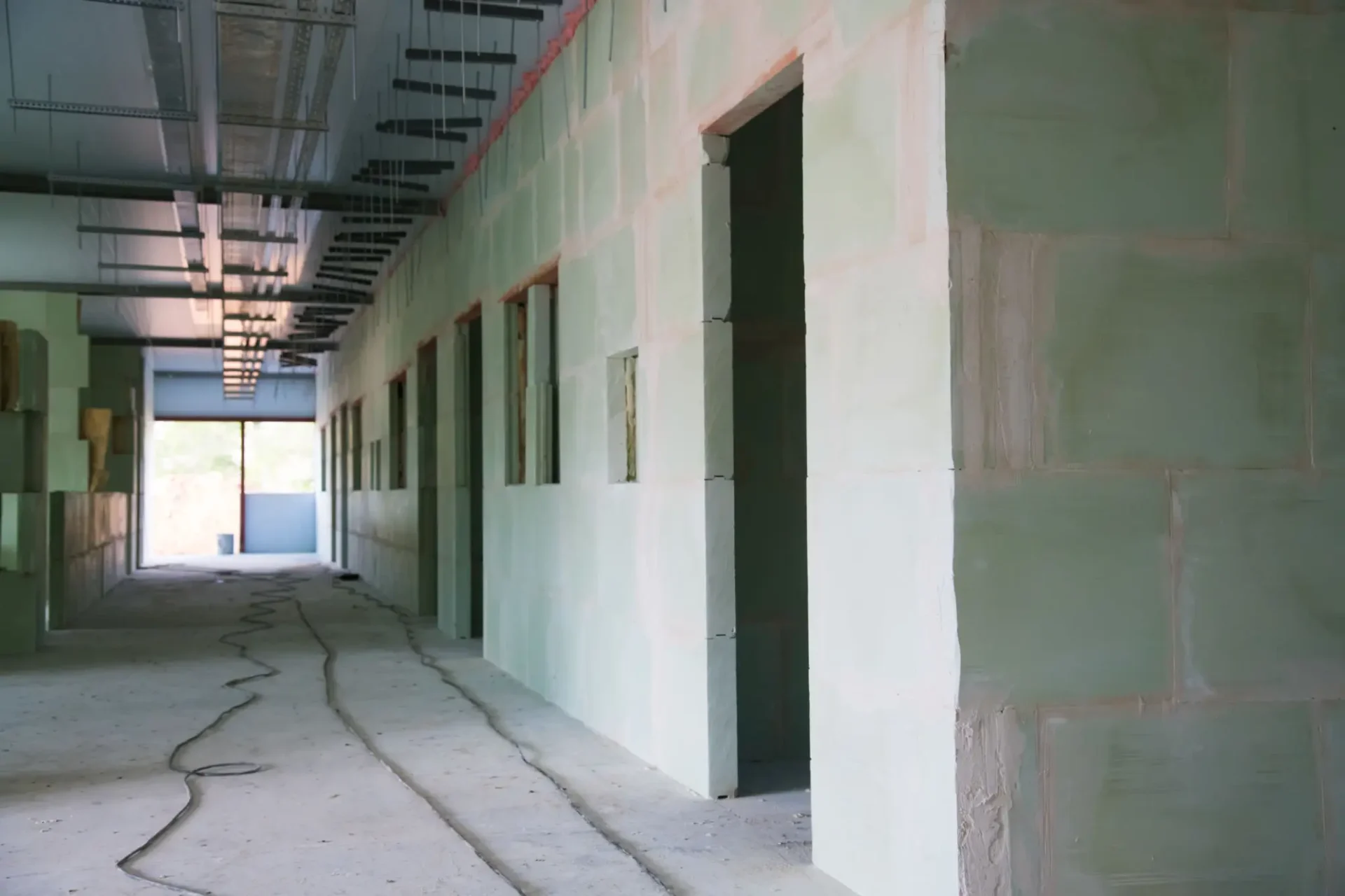 Interior hallway of a building under construction with unfinished walls.