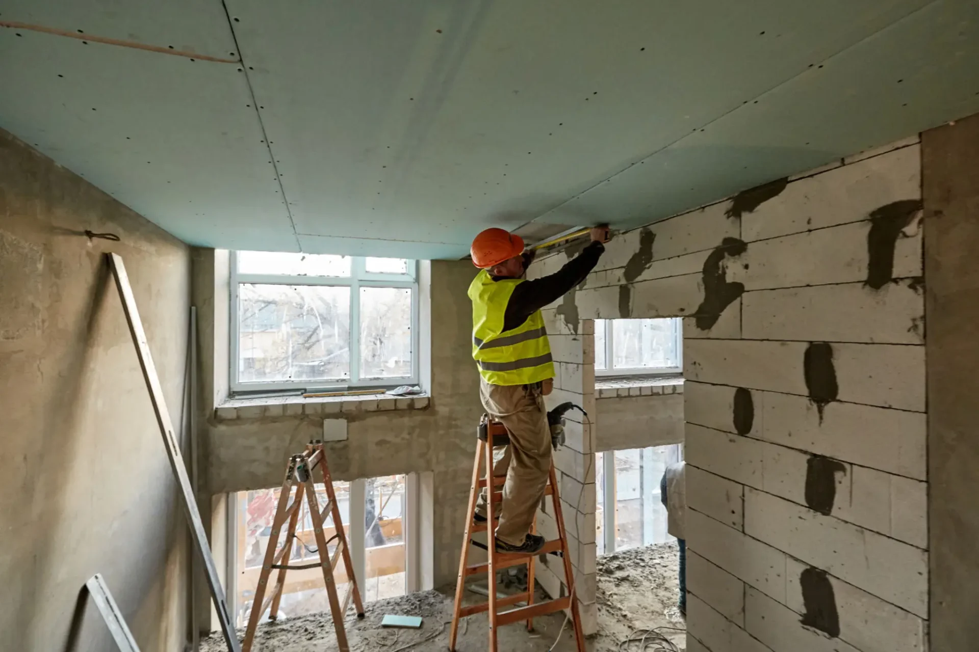 Construction worker installing wall blocks indoors.