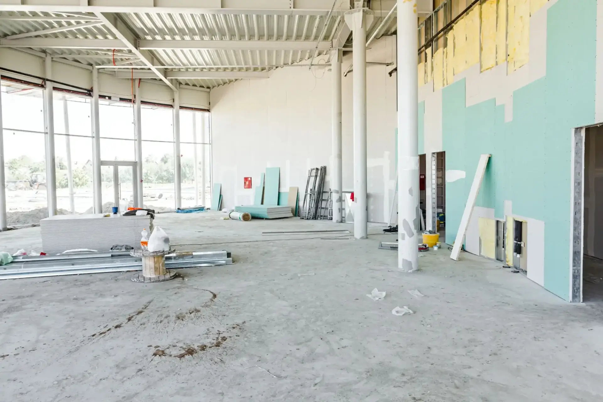 Empty unfinished room with construction materials scattered across the floor.